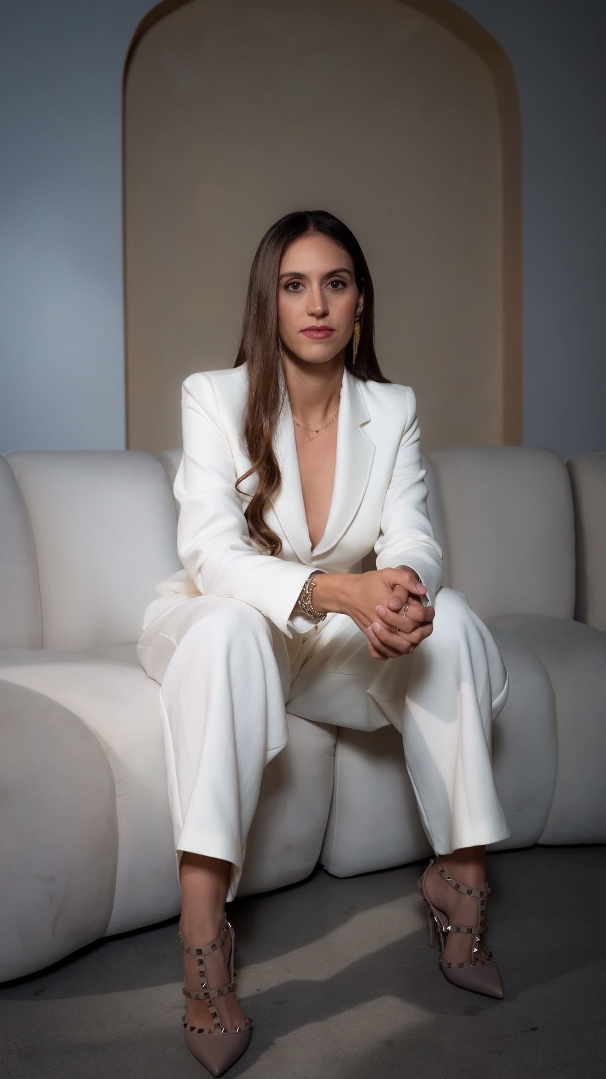 Veronica Lopez-Calleja, Esq., family law attorney, seated in a white suit